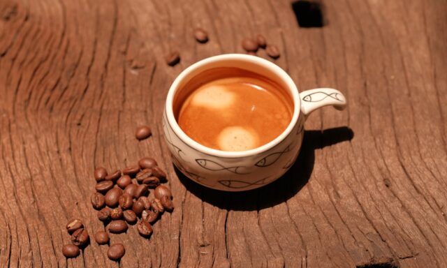 Tasse d'expresso et grains de café sur une table en bois