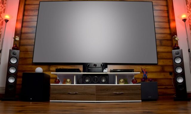 Salle de home cinéma avec grand écran et enceintes colonnes