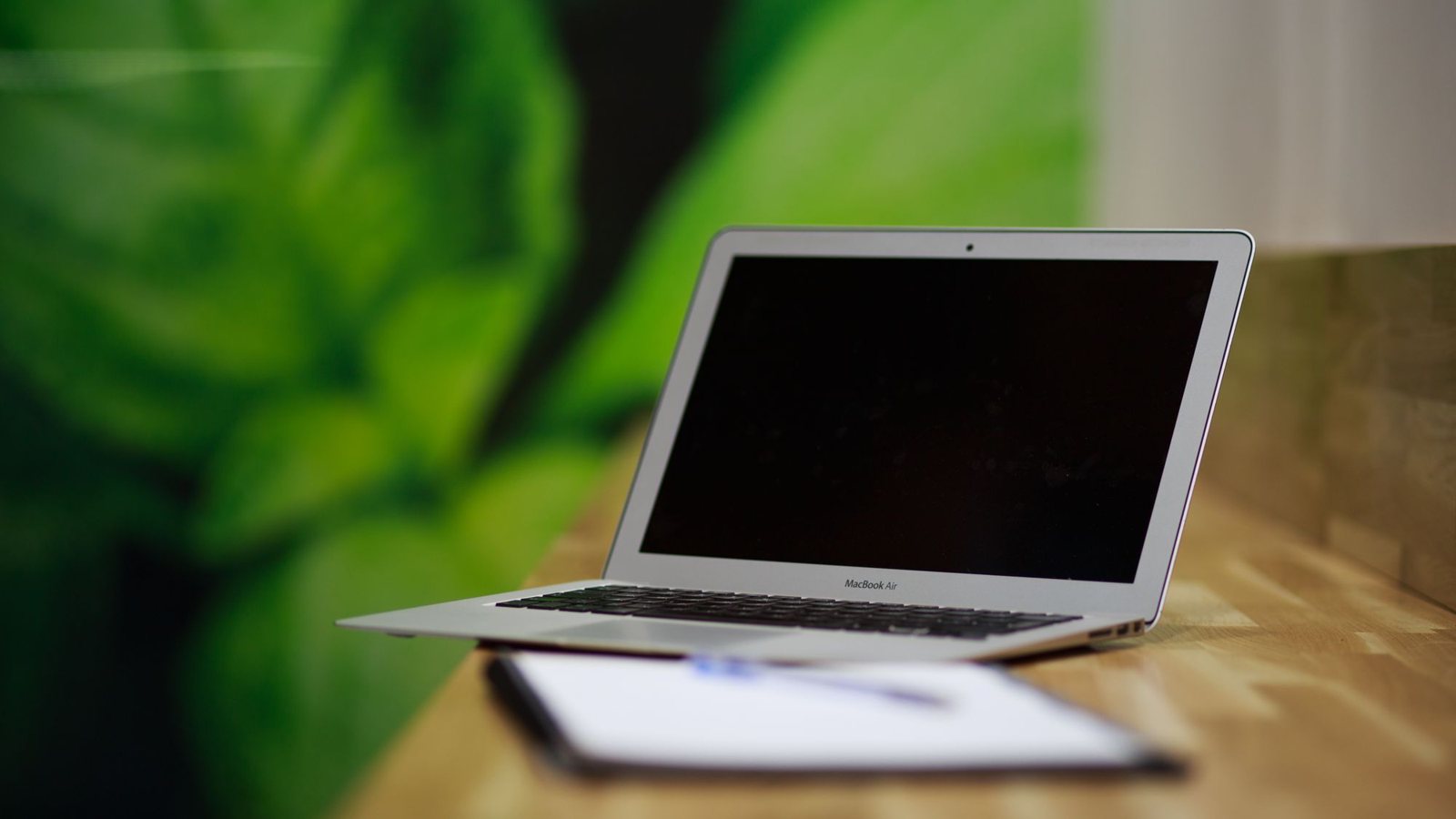 Ordinateur portable argenté ouvert sur un bureau en bois