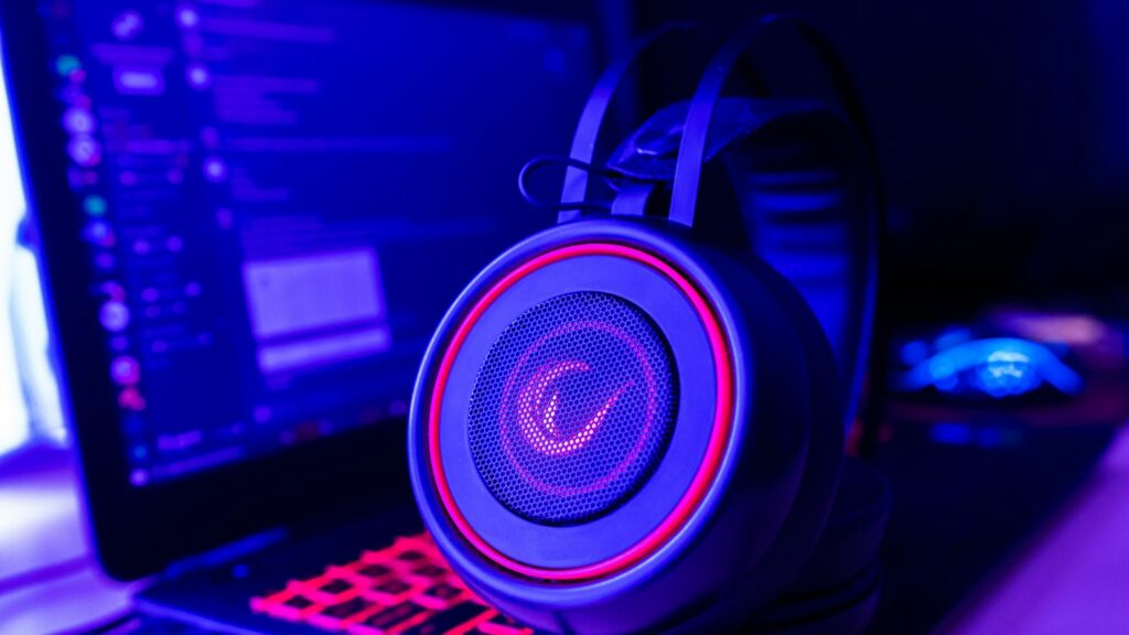 Casque de jeu éclairé posé à côté d'un ordinateur portable