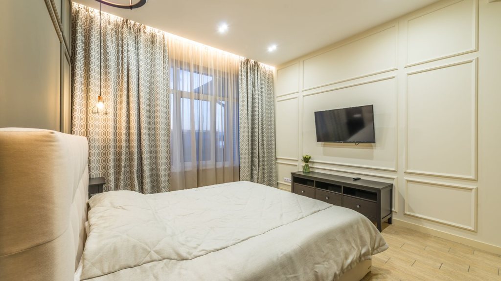 Chambre moderne avec un petit téléviseur posé sur un meuble bas