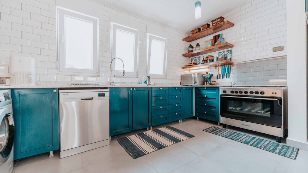 Cuisine ouverte avec un lave-vaisselle en inox entre les meubles