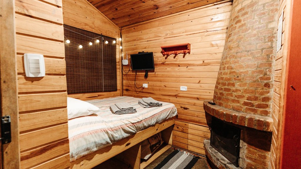Petite télévision fixée au mur d'une chambre en bois
