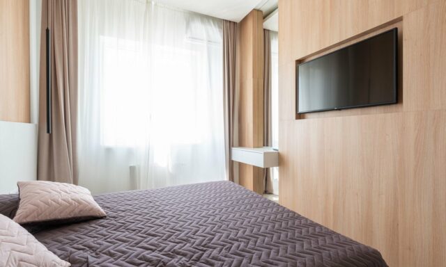 Chambre moderne avec un téléviseur fixé dans une niche murale