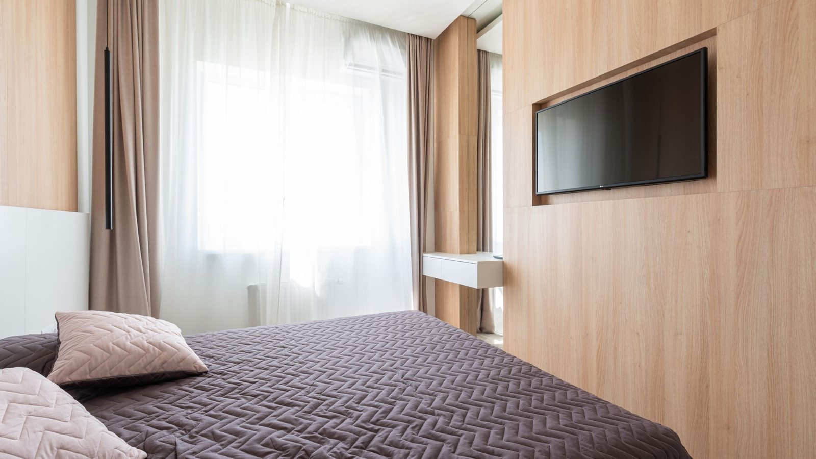 Chambre moderne avec un téléviseur fixé dans une niche murale
